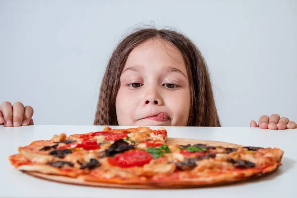 La niña mira la pizza. Niño encontró pizza Fotos de stock libres de derechos