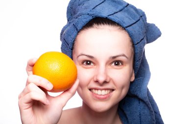 Kafasında havluyla portakallı güzel bir kız.