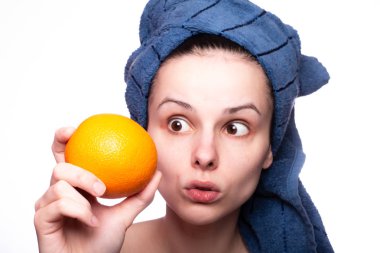 Kafasında havluyla portakallı güzel bir kız.