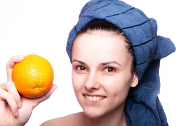 Kafasında havluyla portakallı güzel bir kız.