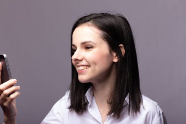 beyaz gömlekli kız telefonda iletişim kuruyor