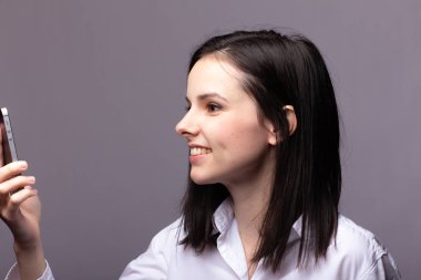 beyaz gömlekli kız telefonda iletişim kuruyor