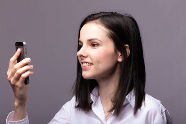 beyaz gömlekli kız telefonda iletişim kuruyor