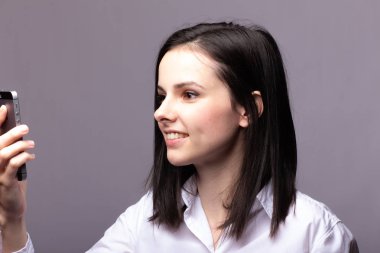 beyaz gömlekli kız telefonda iletişim kuruyor