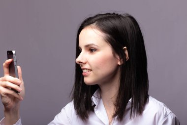 beyaz gömlekli kız telefonda iletişim kuruyor