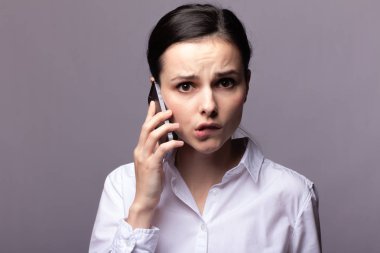 beyaz gömlekli kız telefonda iletişim kuruyor