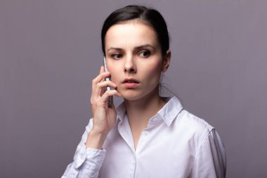 beyaz gömlekli kız telefonda iletişim kuruyor