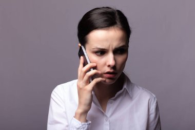 beyaz gömlekli kız telefonda iletişim kuruyor