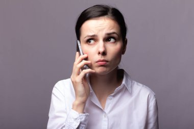 beyaz gömlekli kız telefonda iletişim kuruyor