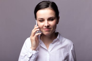 beyaz gömlekli kız telefonda iletişim kuruyor
