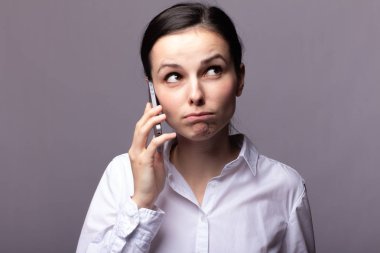 beyaz gömlekli kız telefonda iletişim kuruyor