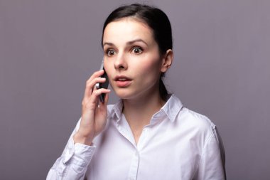 beyaz gömlekli kız telefonda iletişim kuruyor