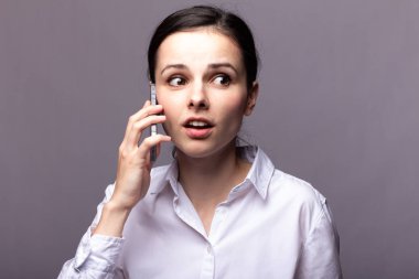 beyaz gömlekli kız telefonda iletişim kuruyor