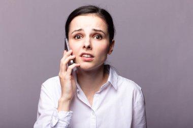 beyaz gömlekli kız telefonda iletişim kuruyor