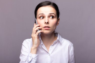 beyaz gömlekli kız telefonda iletişim kuruyor