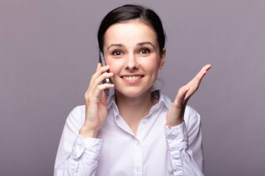 beyaz gömlekli kız telefonda iletişim kuruyor