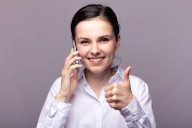 beyaz gömlekli kız telefonda iletişim kuruyor