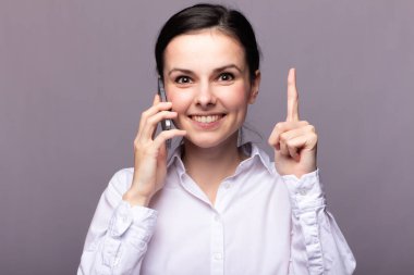 beyaz gömlekli kız telefonda iletişim kuruyor