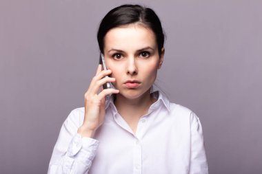 beyaz gömlekli kız telefonda iletişim kuruyor