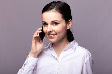 beyaz gömlekli kız telefonda iletişim kuruyor