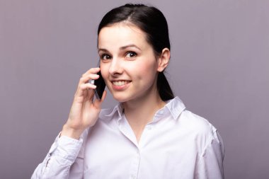 beyaz gömlekli kız telefonda iletişim kuruyor