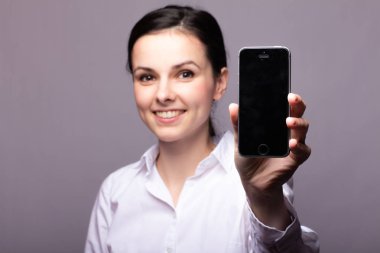 beyaz gömlekli kız telefonda iletişim kuruyor