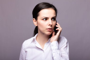 beyaz gömlekli kız telefonda iletişim kuruyor