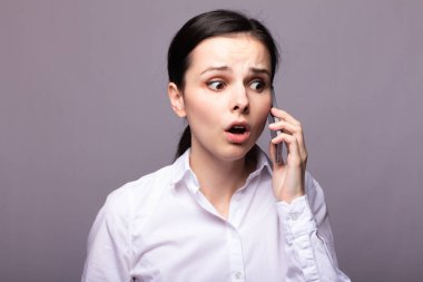 beyaz gömlekli kız telefonda iletişim kuruyor