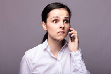 beyaz gömlekli kız telefonda iletişim kuruyor