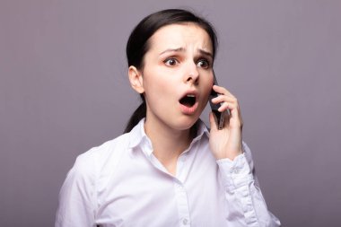 beyaz gömlekli kız telefonda iletişim kuruyor