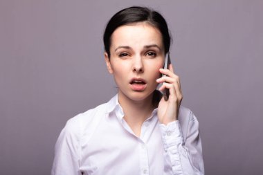 beyaz gömlekli kız telefonda iletişim kuruyor