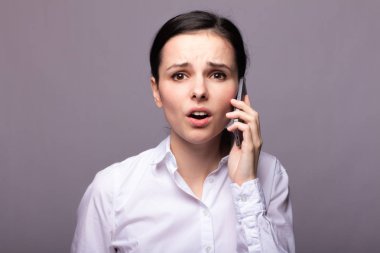 beyaz gömlekli kız telefonda iletişim kuruyor