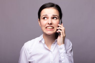 beyaz gömlekli kız telefonda iletişim kuruyor