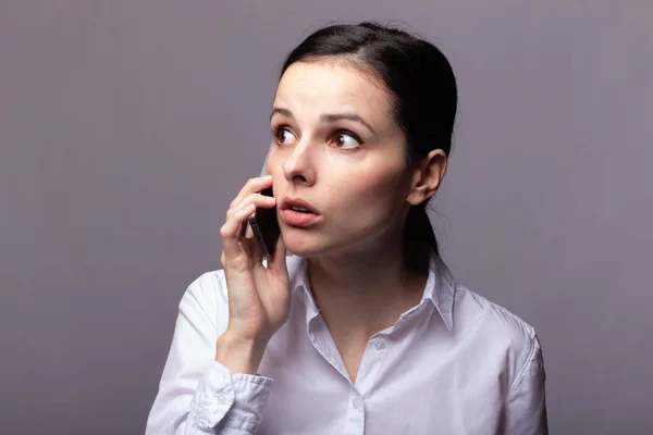 girl in a white shirt  communicates on the phone