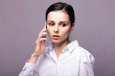 beyaz gömlekli kız telefonda iletişim kuruyor