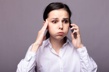 beyaz gömlekli kız telefonda iletişim kuruyor