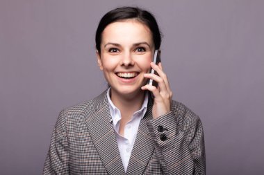 Beyaz gömlekli güzel bir genç kız, telefonda bir ceket konuşuyor.