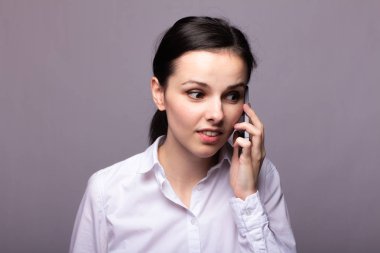 beyaz gömlekli kız telefonda iletişim kuruyor