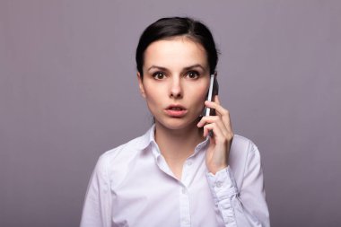 beyaz gömlekli kız telefonda iletişim kuruyor