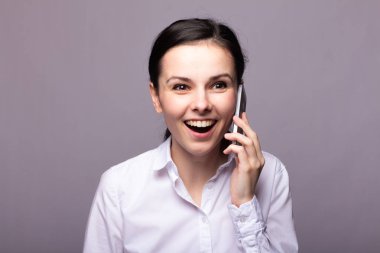 beyaz gömlekli kız telefonda iletişim kuruyor