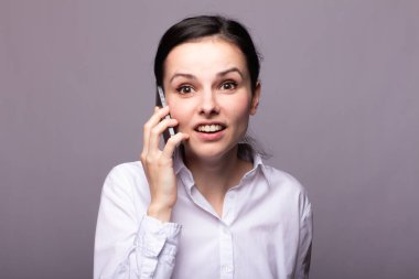 beyaz gömlekli kız telefonda iletişim kuruyor