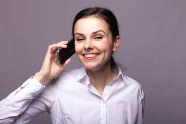 beyaz gömlekli kız telefonda iletişim kuruyor