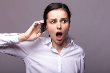 beyaz gömlekli kız telefonda iletişim kuruyor