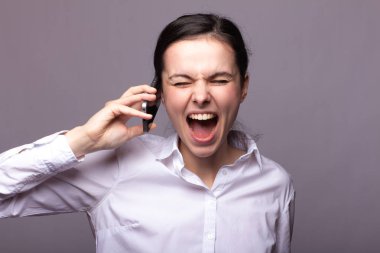 beyaz gömlekli kız telefonda iletişim kuruyor