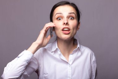 beyaz gömlekli kız telefonda iletişim kuruyor