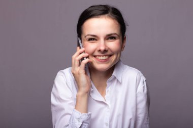 beyaz gömlekli kız telefonda iletişim kuruyor