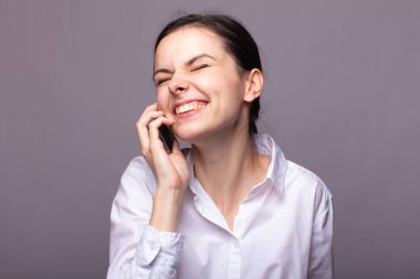 beyaz gömlekli kız telefonda iletişim kuruyor