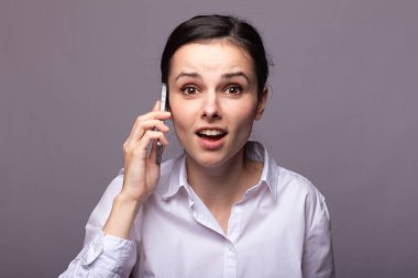 beyaz gömlekli kız telefonda iletişim kuruyor