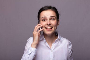 beyaz gömlekli kız telefonda iletişim kuruyor