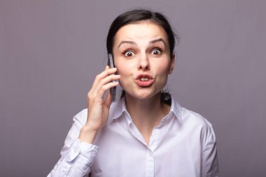 beyaz gömlekli kız telefonda iletişim kuruyor